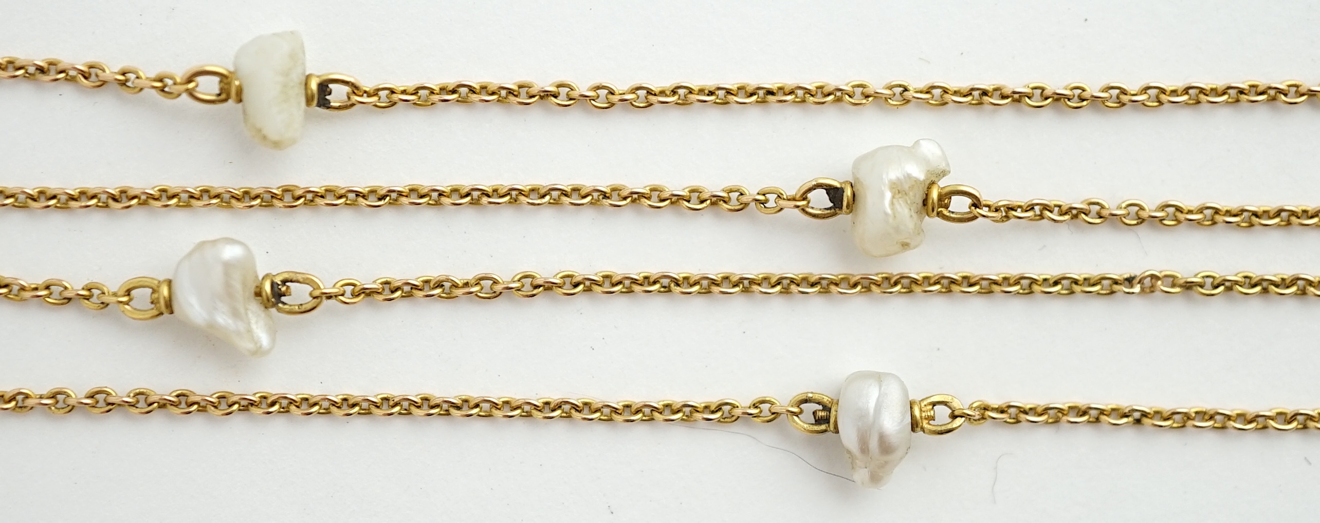 An early 20th century 15ct gold and ten stone baroque pearl set chain necklace